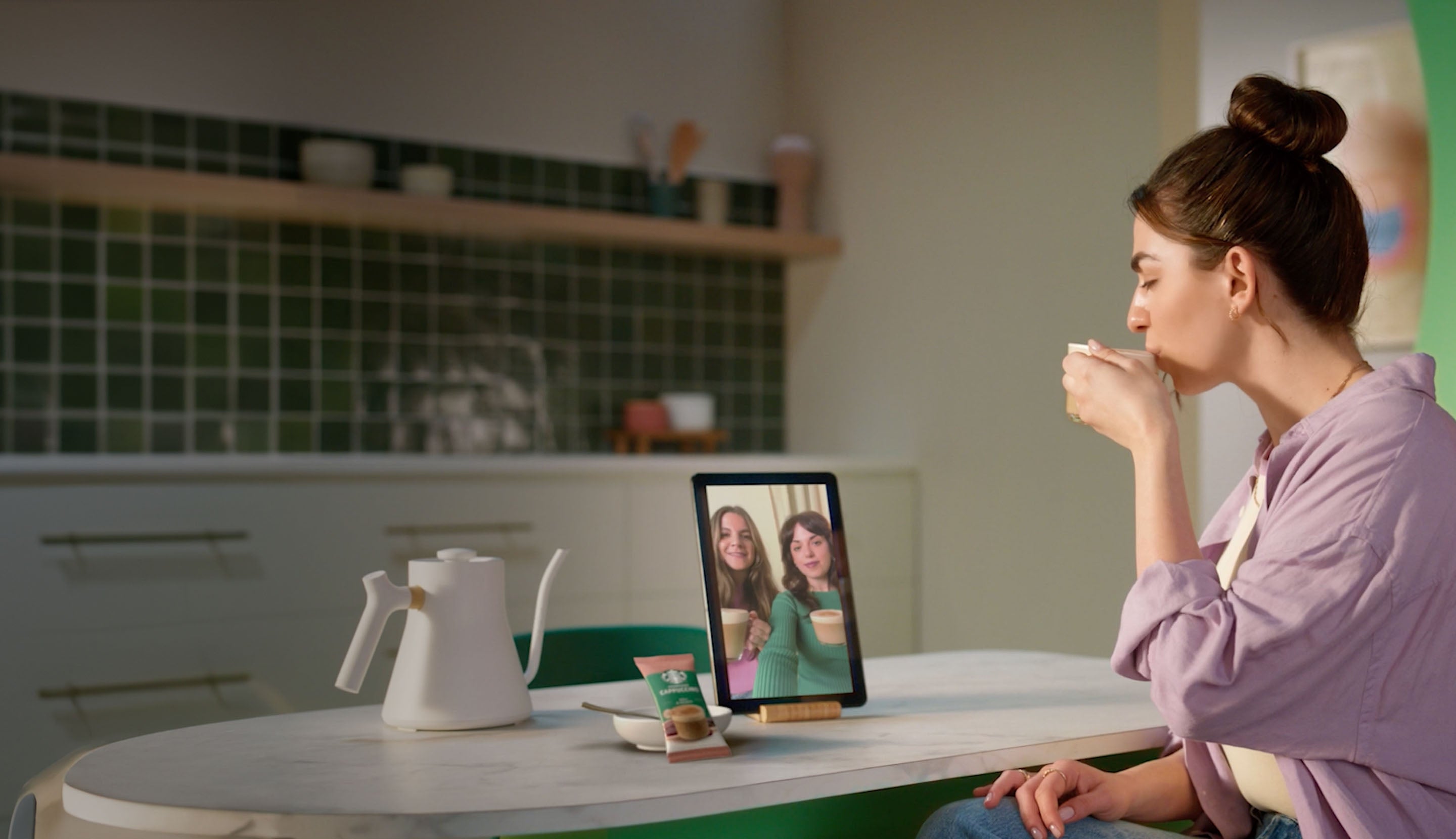 Une femme boit une boisson instantanée premium de Starbucks® et discute avec des amis